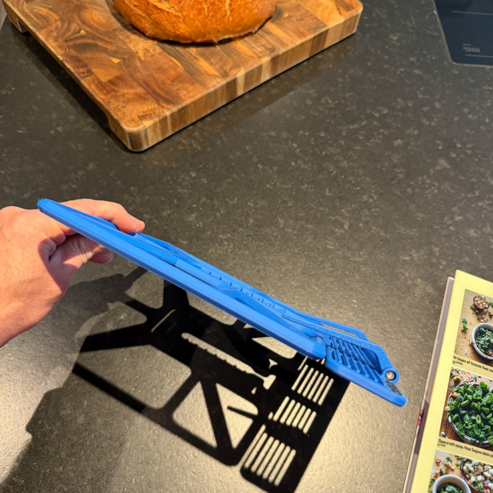 Read Dock in Slate Blue auf der Küchenplatte zusammengeklappt in der Hand